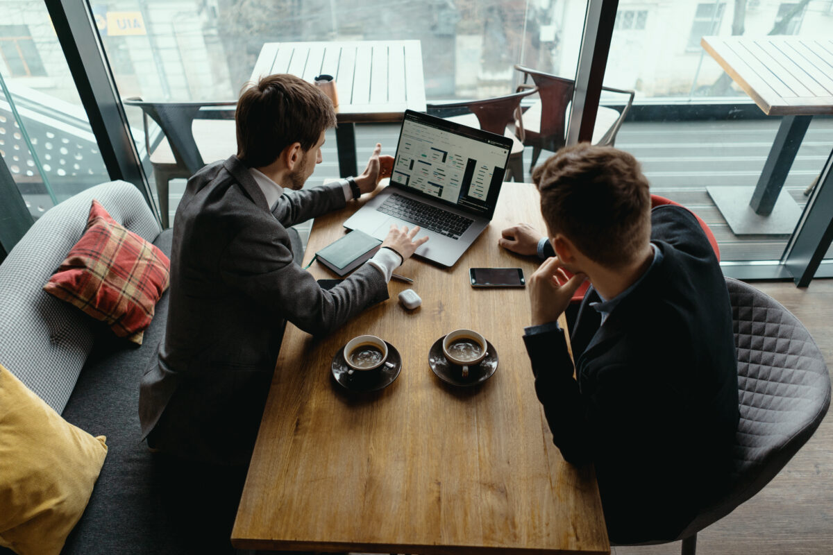 B2B web design companies discussing website analytics and performance on a laptop during a meeting